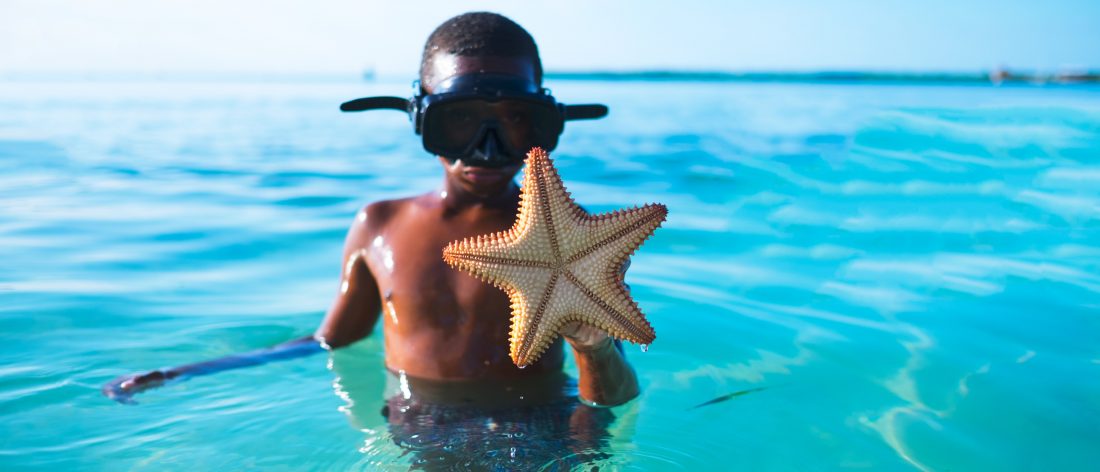 Kid playing in the ocean, observing water safety rules