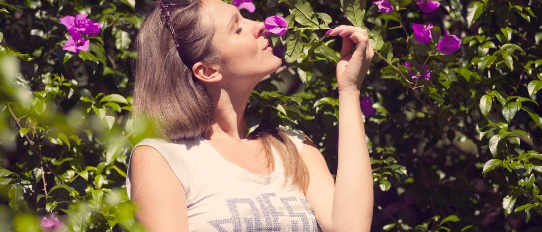 Woman with flowers using her fives senses