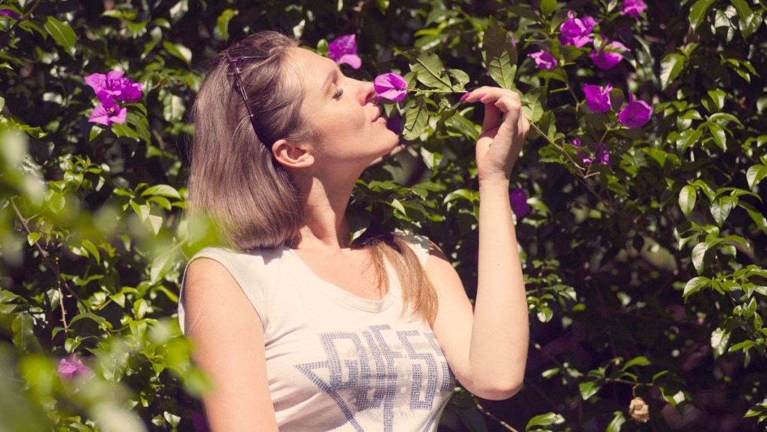 Woman with flowers using her fives senses