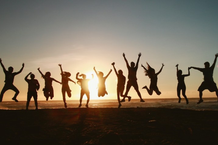 Group of loving people on the beach at sunset