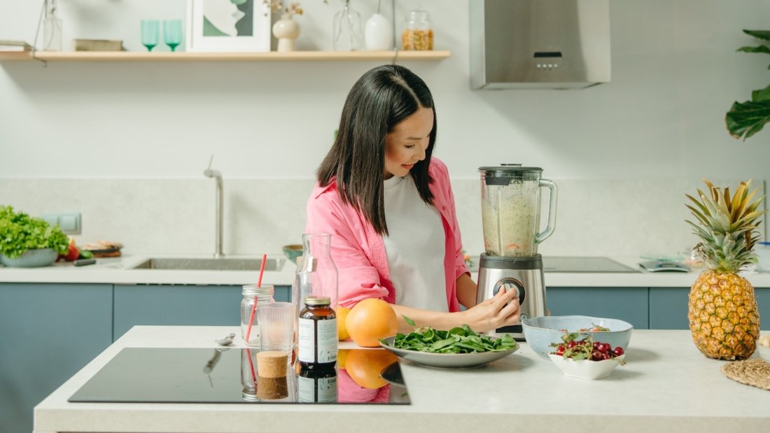 Healthy woman making a smoothie