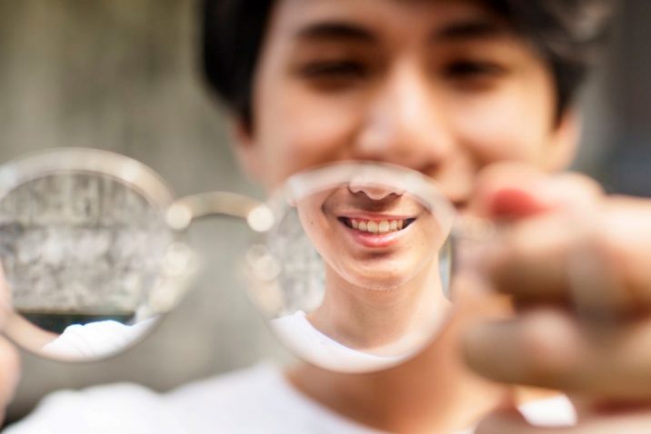 Holding up glasses to improve vision