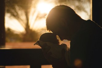 Man holding and selflessly loving a baby
