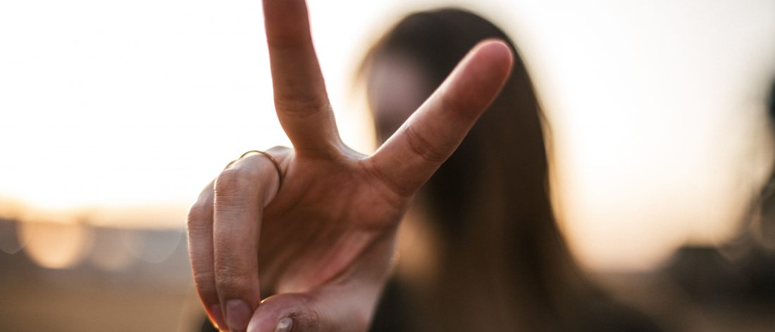 A woman making the peace sign