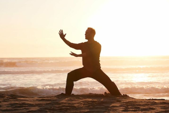 Man on beach practicing Qigong
